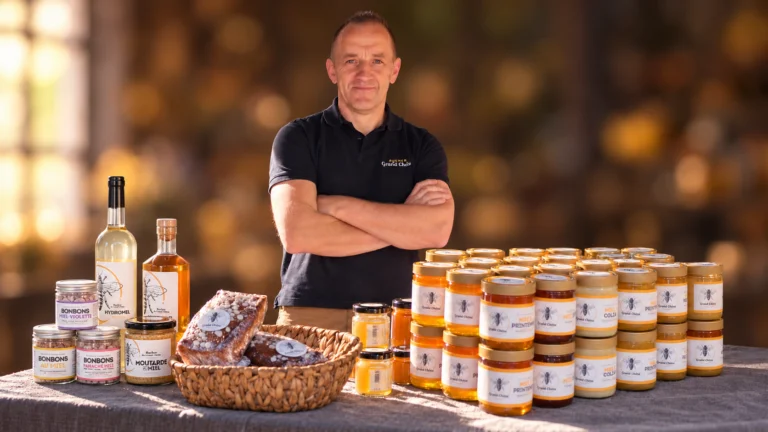 Imker achter zijn potten honing en andere producten van de bijenkast